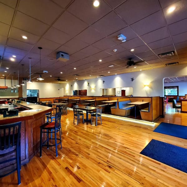 Spacious dining room at La Rumba Restaurant Latino with a bar, tables, and booth seating.